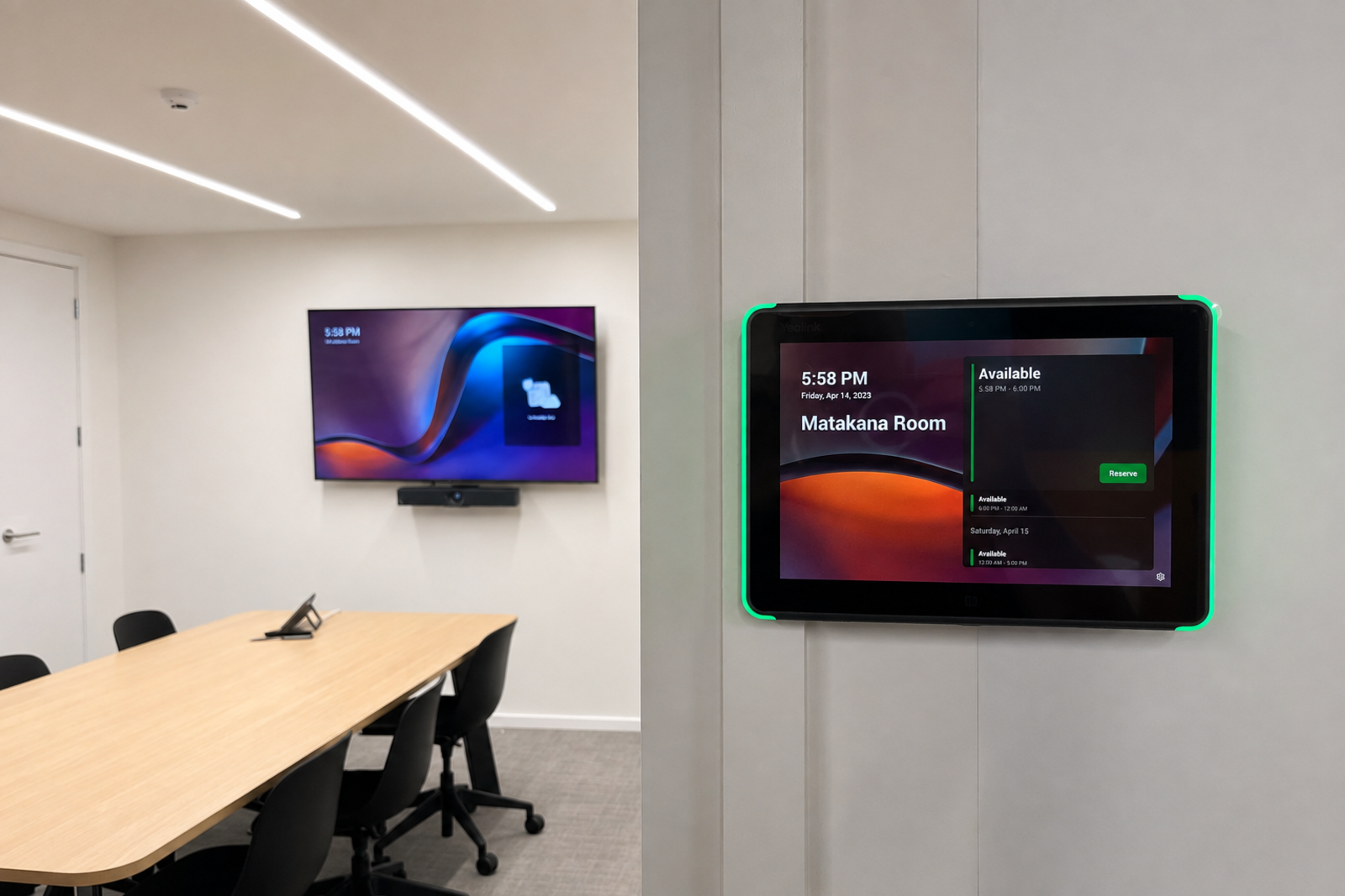 A meeting room with a wall-mounted display and camera, and a room booking panel showing the Matakana Room as available